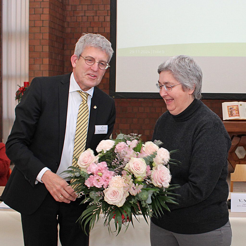 Pfarrerin Antje Umbach erhält von Superintendent Volker Neuhoff einen Blumenstrauß.