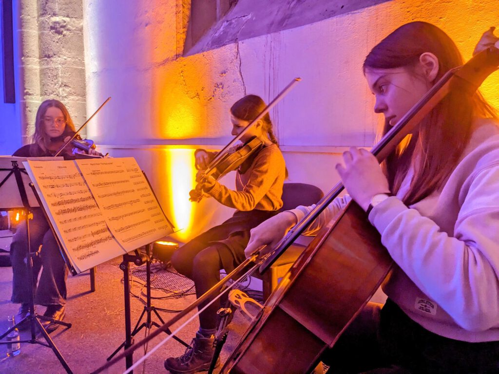 Drei Musikerinnen mit Streichinstrumenten.